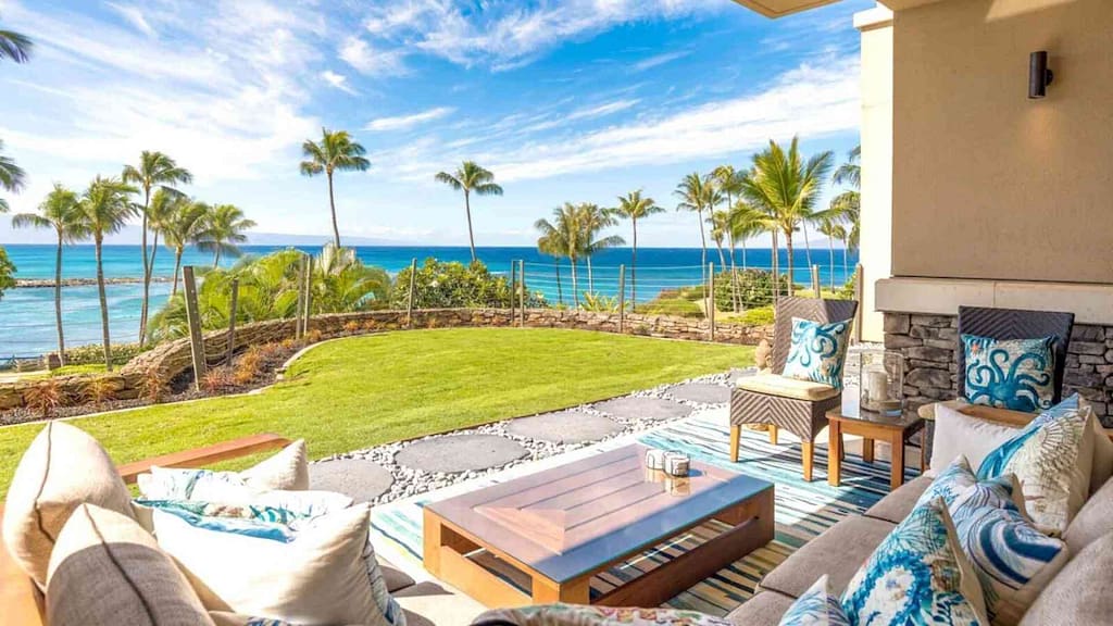 The back deck with view of palm trees and ocean from Maui luxury property Kapalua Bay Villa